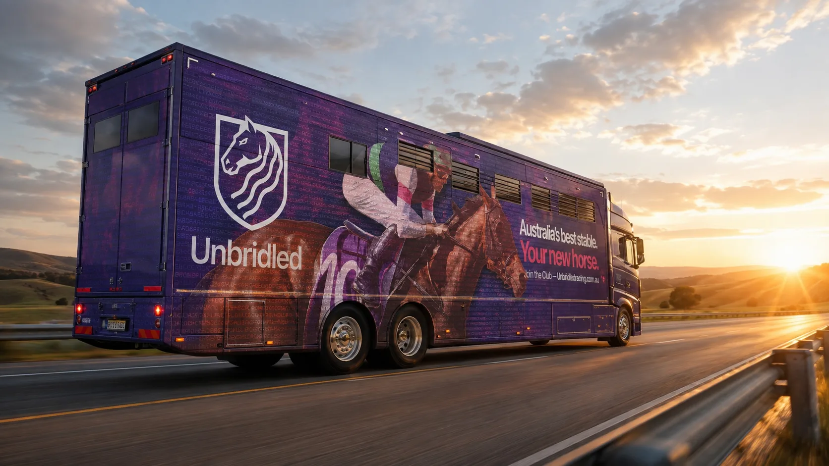 The Unbridled horse truck on the road at sunset, wrapped in the founding owner artwork